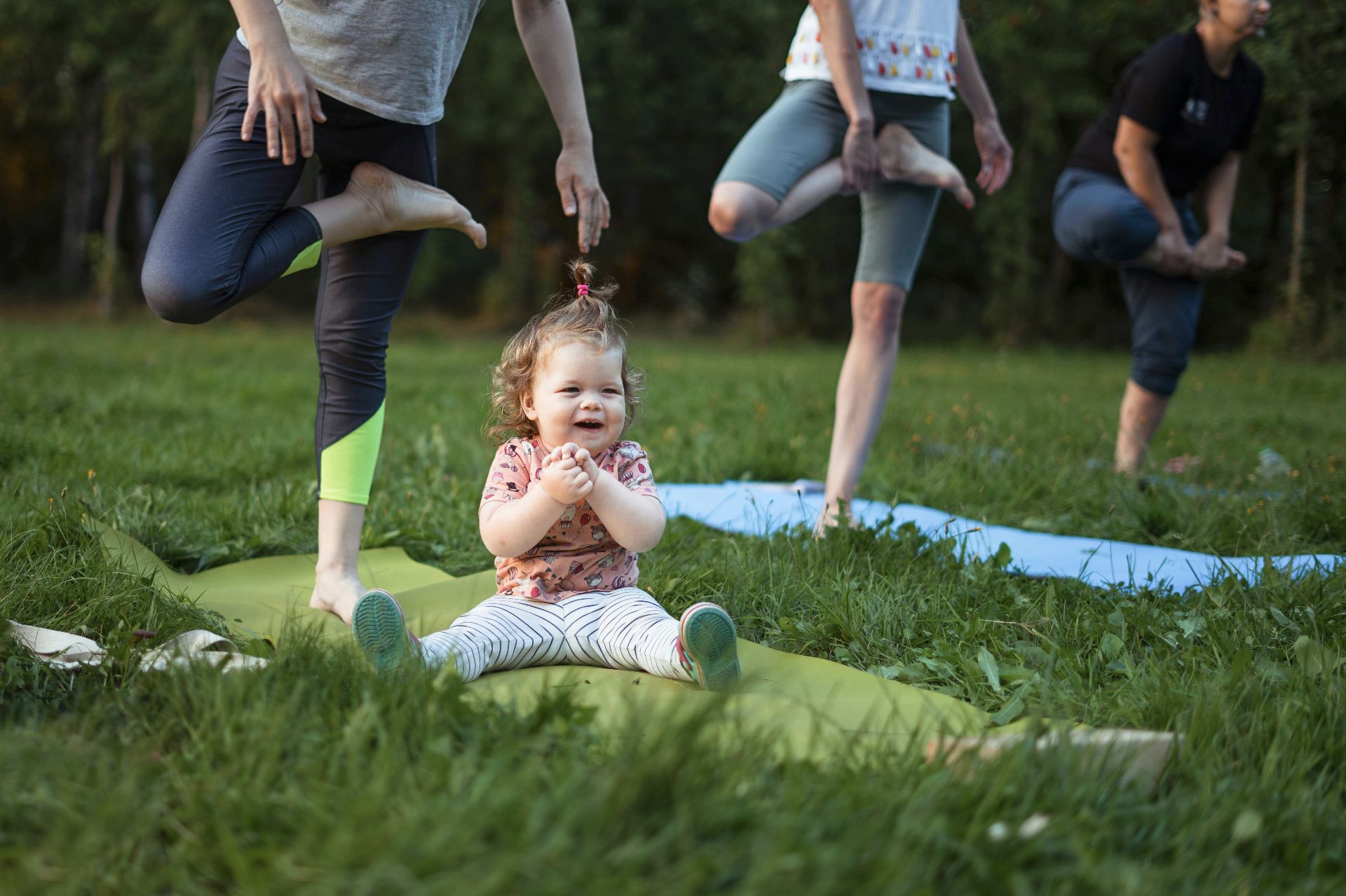 Yoga extérieur, en bébé en premier plan et des adultes en second
